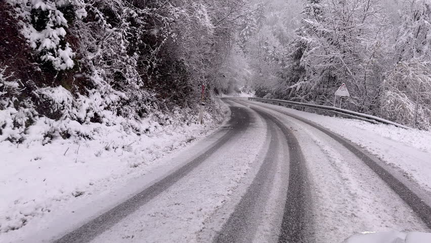 Driving Along Icy Snow-Covered Mountain Road During Winter