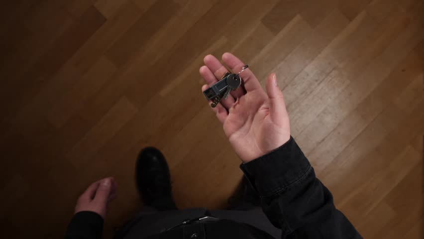 pov Businessman man holding keys standing on wooden floor in new home
