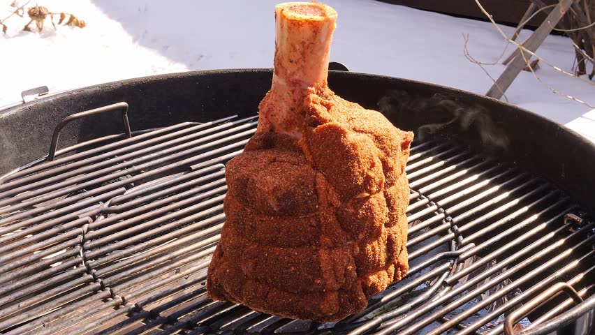 This outdoor grilled tomahawk pork is seasoned with aromatic spices Slowly cooked over charcoal bone-in meat develops crispy crust deep flavor and perfect tenderness for ultimate barbecue experience