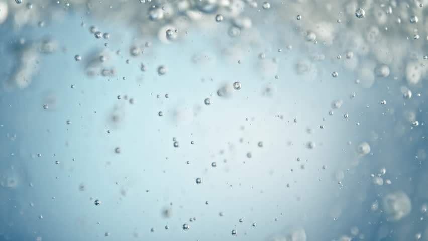 Super Slow Motion Shot of Air Bubbles Flowing in Water on Light Blue Background at 1000fps.