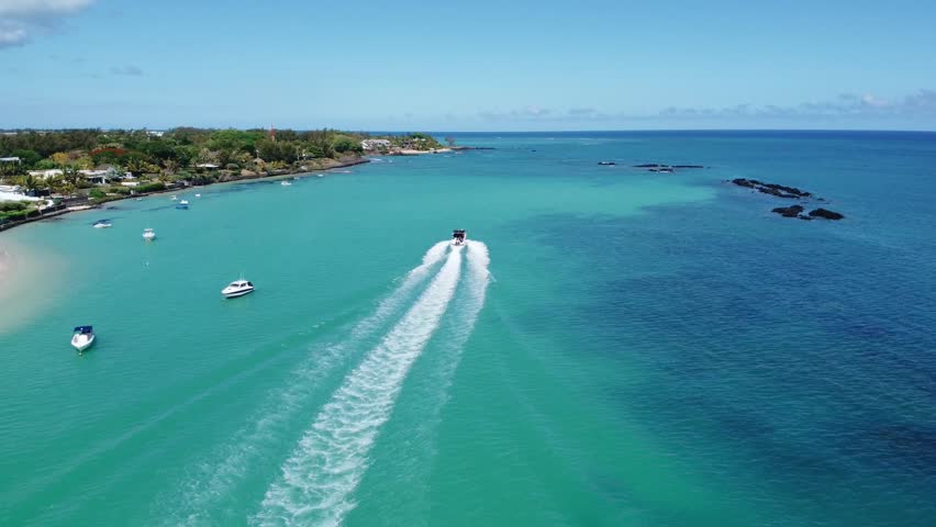 Stunning aerial view of Mauritius' ocean scenery with a speedboat gliding across the scenic bay