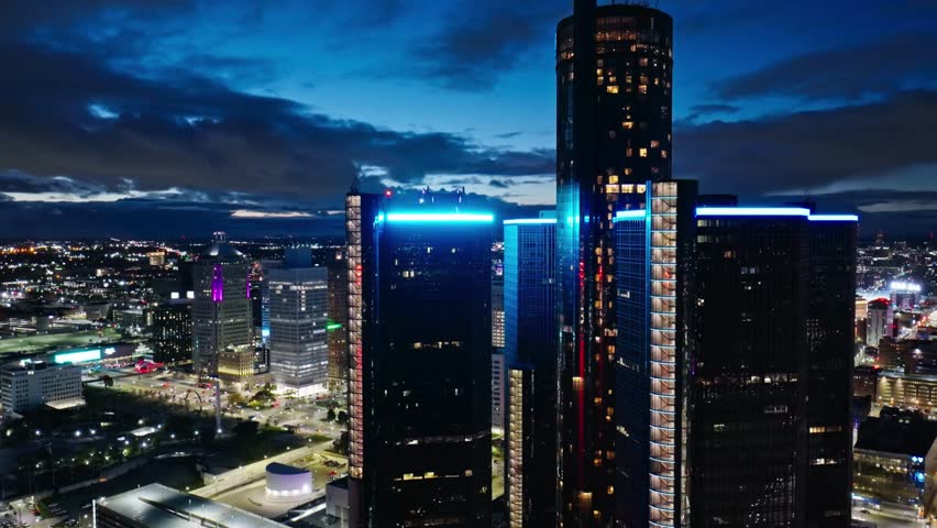 Downtown Detroit skyline at night with illuminated skyscrapers and glowing city lights