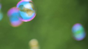 Colorful Large Soap Bubbles in Slow Motion. Holiday Background Birthday Close-up View of Beautiful Big Soap Bubbles is Flying Near Green Trees at Sunny Day. Party Bubbles Shimmering Colors of Rainbow. - Powered by Shutterstock - Get 15% off with code: PIKWIZARD15