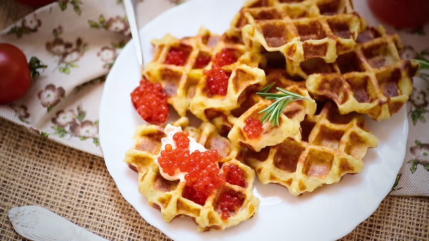 Homemade potato waffles with caviar and herbs for breakfast.