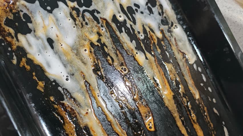 Foaming Detergent Dissolves Grease on Dirty Baking Pan
