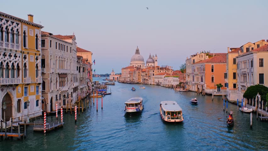 Venice, Italy - July 19, 2019: View of Venice Grand Canal with boats gondola and vaporetto and Santa Maria della Salute church in the day from Ponte dell