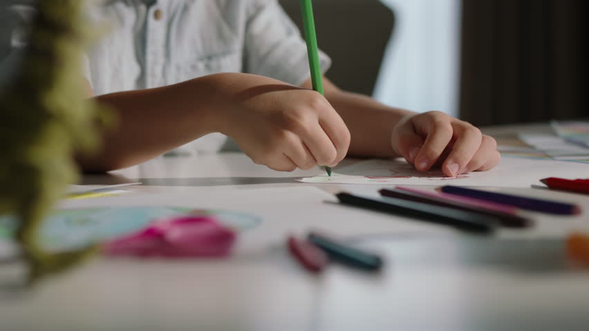 Unknown kid drawing, hands close up. Childhood bliss drawings of boy, intricately detailed with pencil. Imagination soars, creative potential blossoms, foundation for lifetime of artistic expression