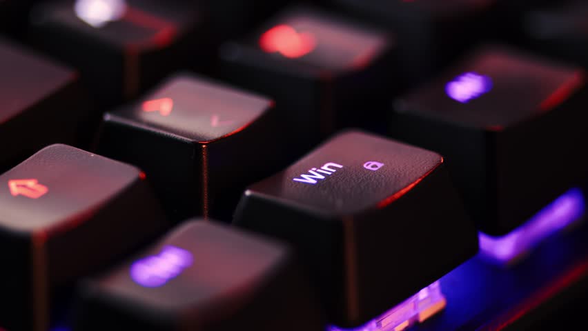 Human finger is clicking on the WIndows button on the computer keyboard, close up view. The finger presses Windows on the keyboard key, macro shot. Loop footage. 
