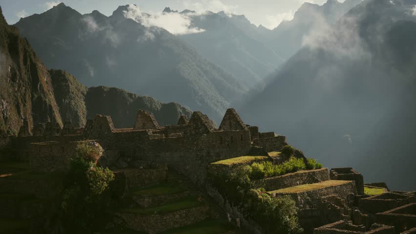 Clouds roll over the ruins of Machu Picchu, Peru, in a mesmerizing time lapse at sunrise with visitors ascending stairs in tour group
