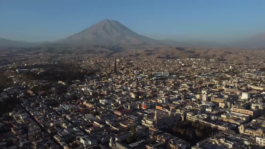 Aerial drone establishing of Arequipa, Peru, city streets and rooftops with Misti volcano in the distance