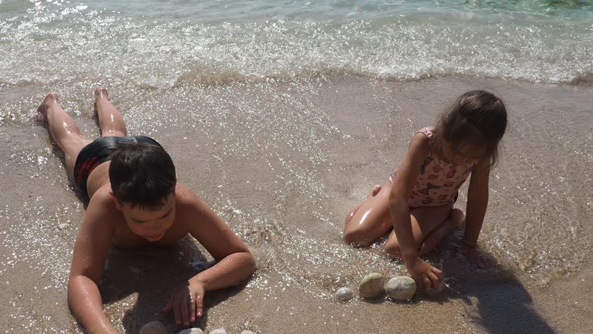 Big happy family boy, girl brother, sister on vacation playing in the sand on beach. children enjoy summer holidays relaxation . The blue sky, the sun, fresh sea wind. Pleasure nature communication.