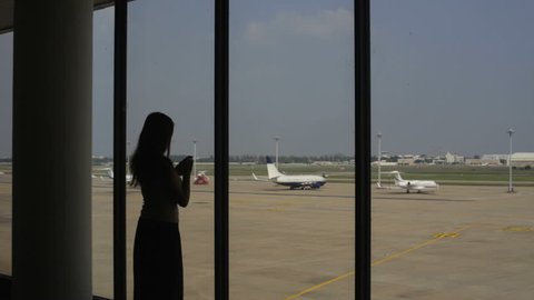 Girl speaks by a mobile phone at the airport