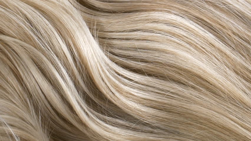 Close-up blond curly hair texture, female long hair background in slow motion