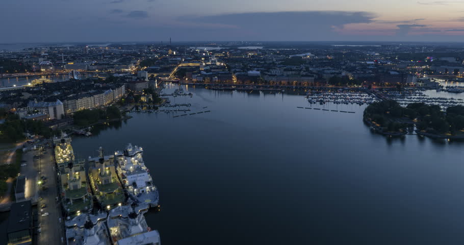 Hyperlapse drone shot of the illuminated Helsinki north harbor, dusk in Finland