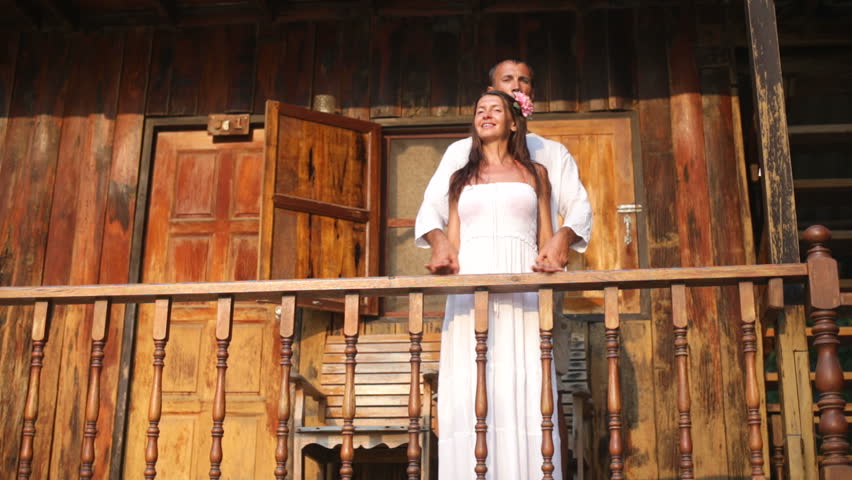 An attractive happy diverse couple in front of their home in love