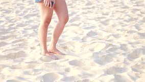 Woman playfully kicking sand on sunny Phuket beach in Thailand - Powered by Shutterstock - Get 15% off with code: PIKWIZARD15