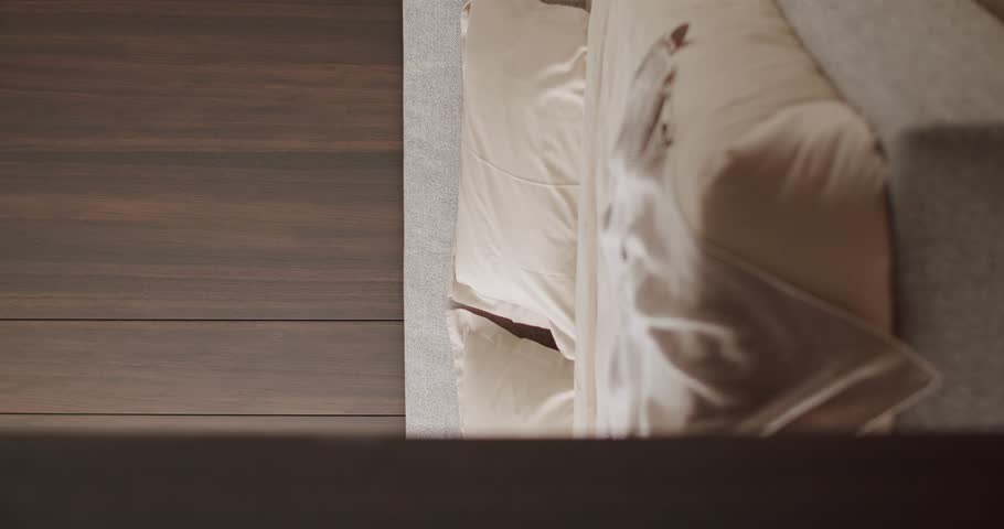 Top view of a modern cozy bed featuring neutral linens and a stylish wooden headboard Vertical, creating a warm and inviting bedroom ambiance. Cozy Vertical Bedroom with Neutral Tones Bedding