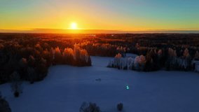 Drone aerial landscape of sunrise light rays with clouds breaking over snowy ice forest pine tree woodlands wilderness in cold valley countryside rural town Latvia Europe travel tourism environment - Powered by Shutterstock - Get 15% off with code: PIKWIZARD15