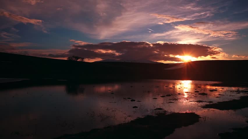 Time lapse of clouds moving over the lake at sunset