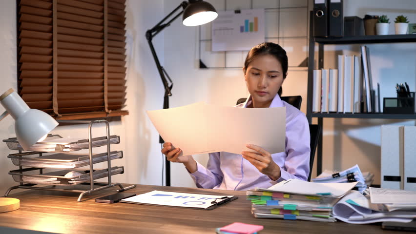 Businesswoman employee working overtime late night feeling tired and stress out with new business project problem on laptop in office