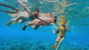 Group of female tourists snorkels in the tropical water. Young woman looking in camera and showing sign of heart. Bali. Indonesia - Powered by Shutterstock - Get 15% off with code: PIKWIZARD15