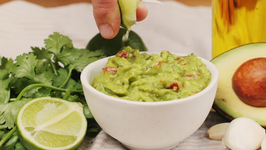 Guacamole dip, traditional mexican food in restaurant for nachos, close up of avocado plate for vegetarians.