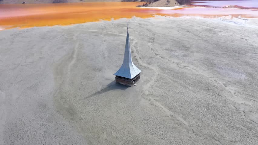 Mining toxic mud residuals in decanting lake choked a church aerial slow motion view