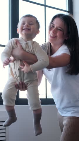 Excited Mother And Baby Boy Playing Together At Home