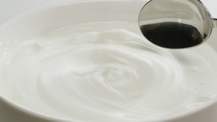 Pouring kefir yogurt into glass cup close-up. Glass with kefir or milk, lactic acid product dairy products concept. Drinking fresh lactose free in morning.