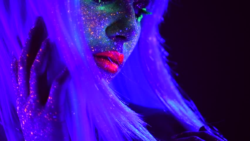 Fashion model dancing woman in neon light, beautiful model girl colorful bright fluorescent make-up, painted skin, Body art design, disco female in UV, colorful make up. Night club. Slow motion