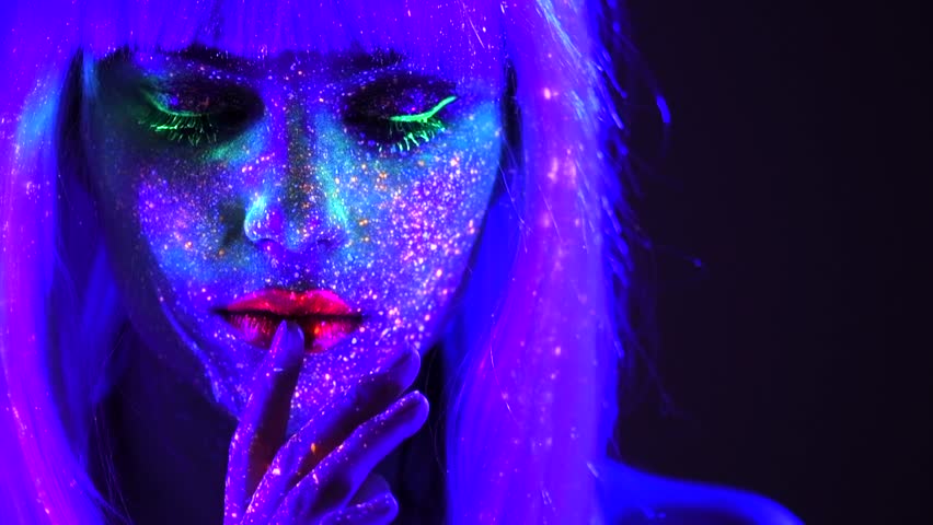 Fashion model dancing woman in neon light, beautiful model girl colorful bright fluorescent make-up, creative painted skin, disco body art design in UV, colorful make up. Night club. Slow motion