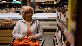 Senior Woman Selecting Wine Bottle in Supermarket Aisle - Powered by Shutterstock - Get 15% off with code: PIKWIZARD15