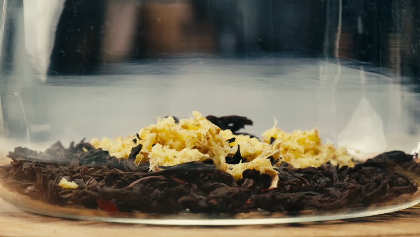 Ginger tea, freshly brewed black organic herbal tea with ginger, mint and lemon in a glass teapot, medication healthy.