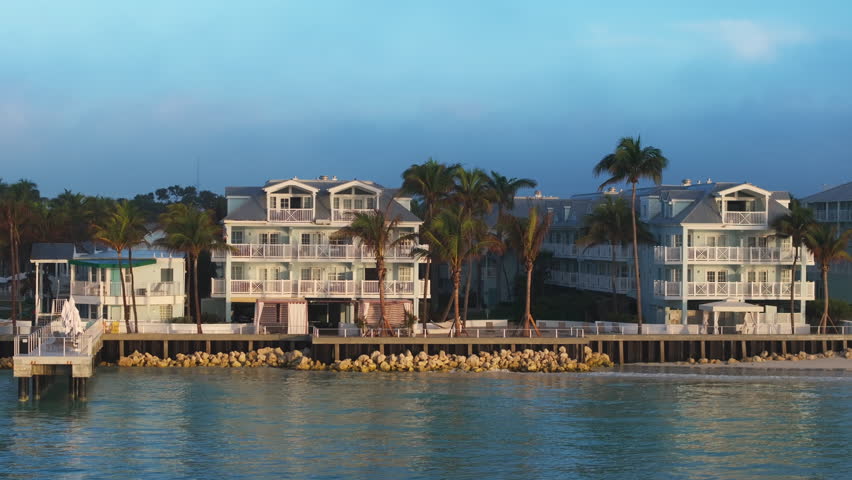 This aerial view showcases the serene allure of Sunset Key in Key West, Florida, highlighting the coastal charm, palm trees, and tranquil watersperfect for relaxation by the beach