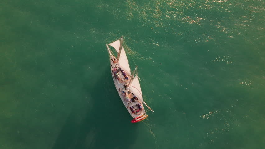 Stunning aerial view of a boat sailing in the turquoise waters of Key West, Florida during sunset, capturing the beauty of this tropical paradise