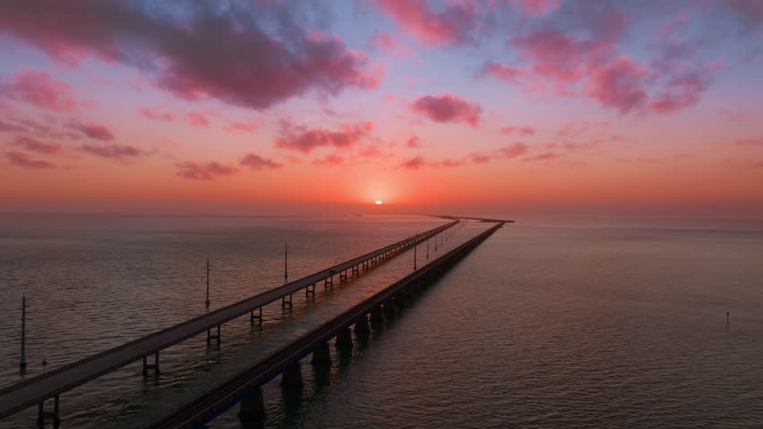 Experience an aerial view of the Overseas Highway to Key West, featuring vibrant sunsets and magnificent ocean horizons for a breathtaking journey of scenic beauty and tranquility