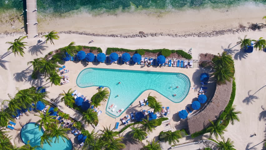 This stunning aerial shot captures a beautiful pool nestled among palm trees and pristine sandy beaches in the enchanting area of Key West, Florida, making it an ideal tropical getaway