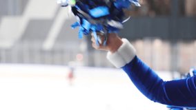 Female cheerleaders group in action, blue and white uniform with pom-pom, audience and hockey teams in the background, performing and supporting during ice hockey game match, cheerleading in ice arena - Powered by Shutterstock - Get 15% off with code: PIKWIZARD15