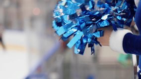 Female cheerleaders group in action, blue and white uniform with pom-pom, audience and hockey teams in the background, performing and supporting during ice hockey game match, cheerleading in ice arena - Powered by Shutterstock - Get 15% off with code: PIKWIZARD15