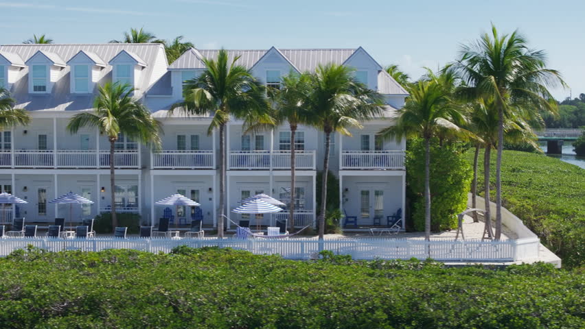 Experience a stunning aerial view of the breathtaking Sunset Key resort located in Key West, Florida, a true paradise, surrounded by lush palm trees and a serene, picturesque beach