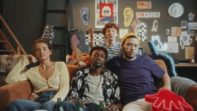 Company of young diverse friends sitting on couch in stylish living room, watching sports on TV, feeling nervous and discussing tense game moment. Zoom shot - Powered by Shutterstock - Get 15% off with code: PIKWIZARD15