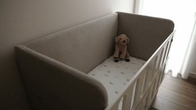Baby crib with soft mattress, decorated with a teddy bear and sunlight coming through the window - Powered by Shutterstock - Get 15% off with code: PIKWIZARD15