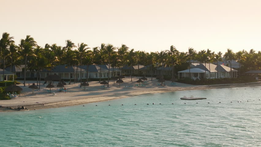 This breathtaking aerial view beautifully captures Sunset Key island during a stunning sunset, showcasing its pristine beaches and lush, vibrant palm trees, all located in Key West, Florida