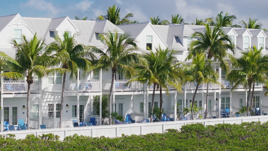 This breathtaking aerial view showcases the stunning beauty of Sunset Key located in Key West, Florida. It features picturesque palm trees complemented by charming beachfront properties