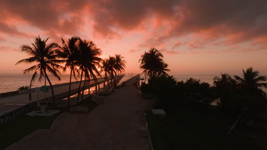 Experience the breathtaking aerial view of the iconic Overseas Highway located in Key West, Florida, highlighting vibrant sunsets and picturesque coastal landscapes bursting with beauty