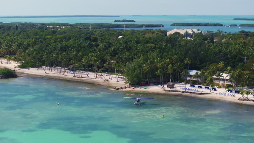 Experience and enjoy stunning aerial views of Key West, Florida, showcasing its beautiful coastline, lush tropical vegetation, and clear turquoise waters - perfect for relaxation or adventure.