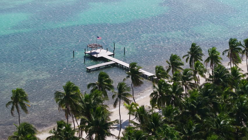 Experience the stunning aerial view of Key West, Florida, with its turquoise waters, sandy beaches, and swaying palm trees, creating an atmosphere of paradise and tranquility