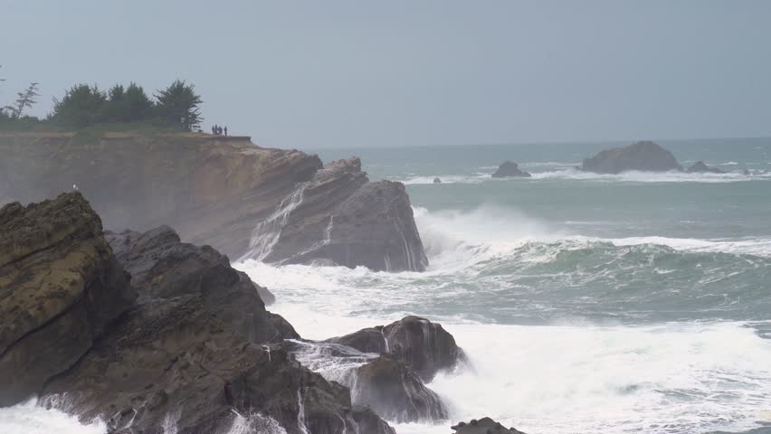 Waves crashing against rocks during a King Tide at Shore Acres, showcasing nature’s power Hand Held
