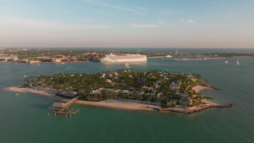 Experience the stunning and breathtaking aerial view of Sunset Key island in Key West, Florida. It showcases beautiful ocean waves, serene beaches, and an incredibly relaxing atmosphere