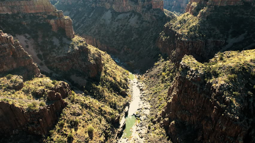 Drone shot of Salt River Canyon showcasing dramatic rock formations, steep cliffs, and the flowing river through the arid terrain.
